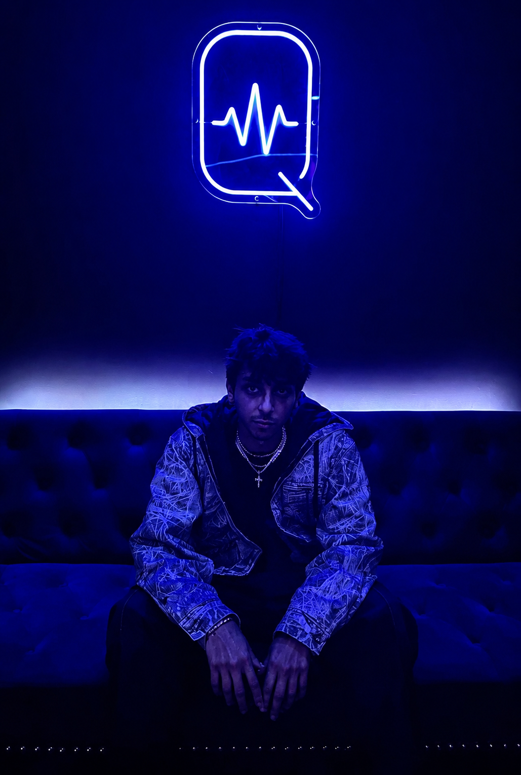 Don.Diego seated beneath a blue studio light